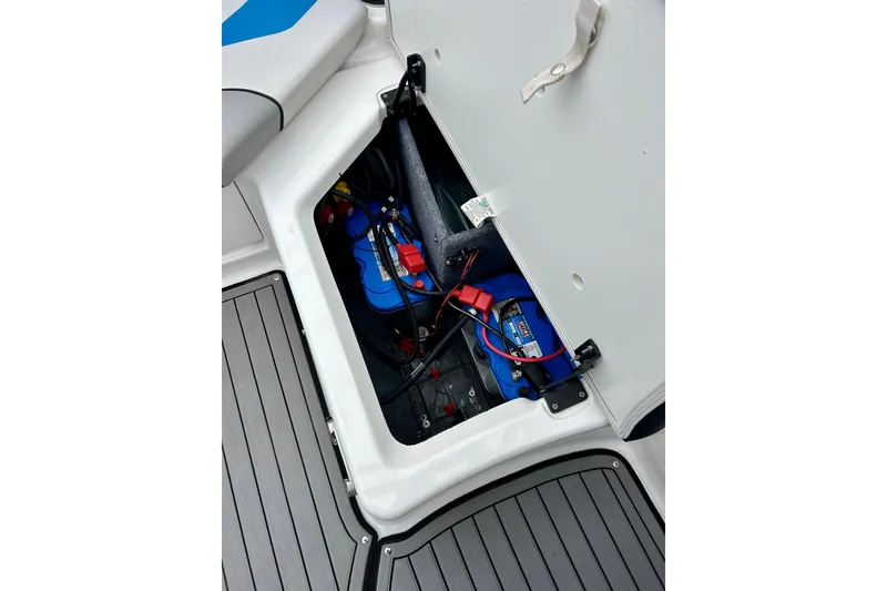 Slide: The Image of Open battery compartment of 2018 Yamaha Boats 242X, showcasing marine battery and wiring. - 50
