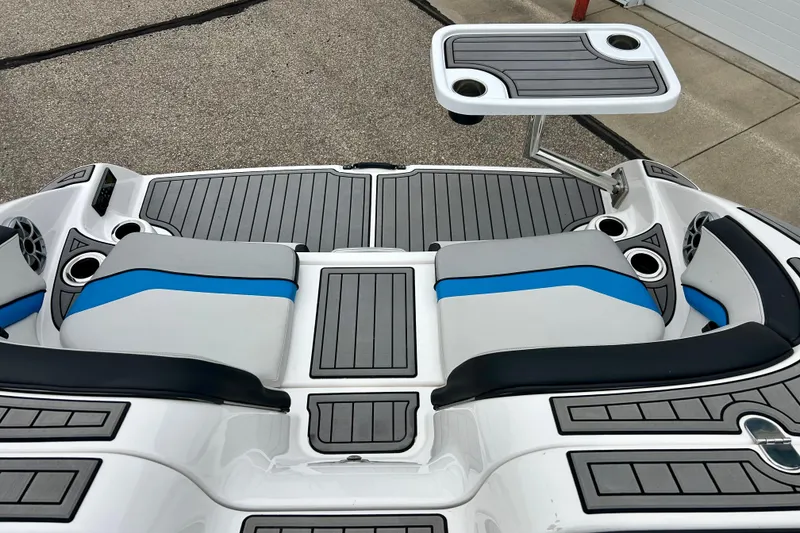 Slide: The Image of 2018 Yamaha Boats 242X interior with seating and table, featuring sleek design and cup holders. - 57