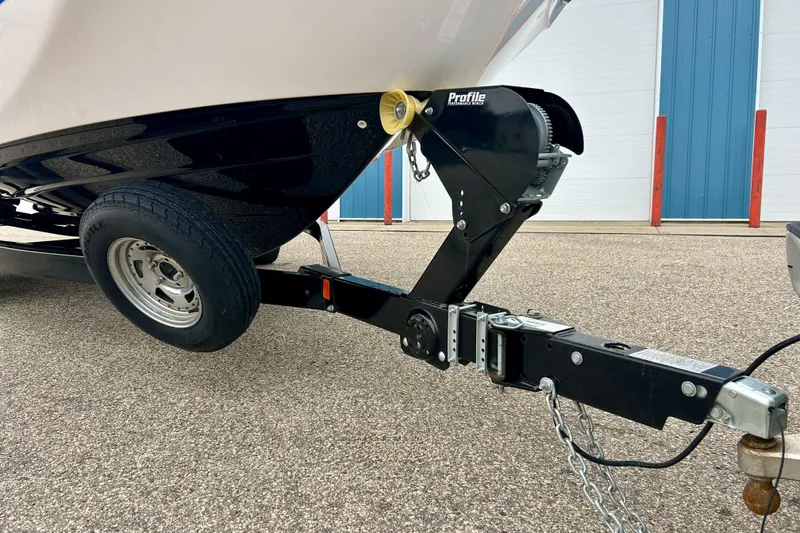 Slide: The Image of Trailer hitch of a 2018 Yamaha Boats 242X, parked on asphalt near a blue building. - 60