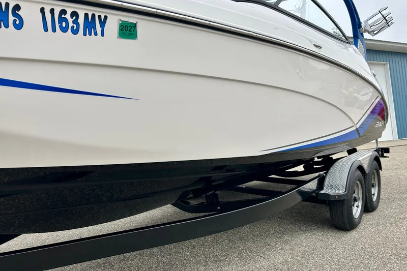 Slide: The Image of 2018 Yamaha Boats 242X on trailer, white hull with blue accents, registration visible. - 62