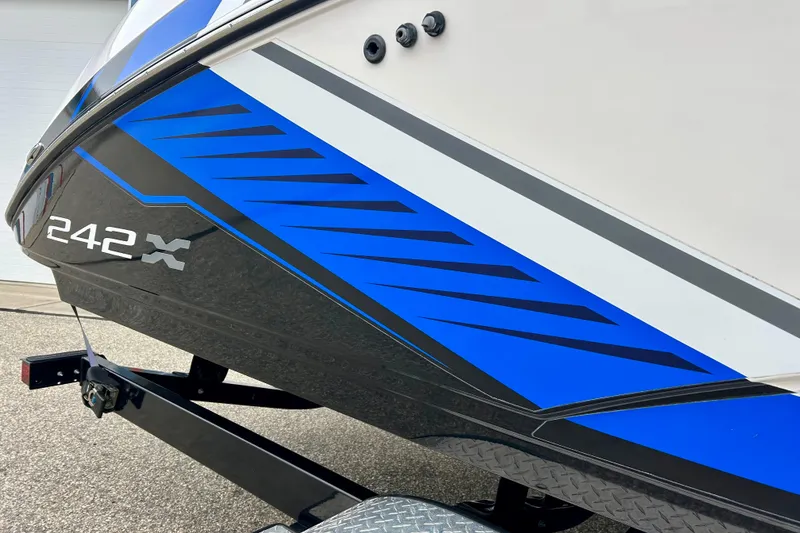 Slide: The Image of 2018 Yamaha Boats 242X with blue and black graphics on a trailer. - 7