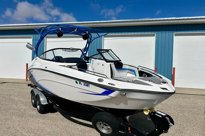 Slide: The Image of 2018 Yamaha Boats 242X on trailer, parked outside blue storage facility. - 74