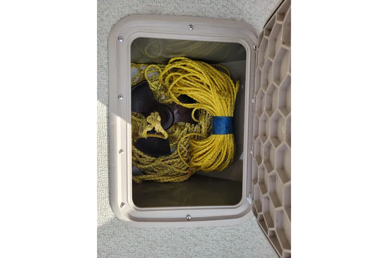 Slide: The Image of Storage compartment with yellow rope and anchor on a 2005 Lowe Fish & Ski 165 boat. - 23