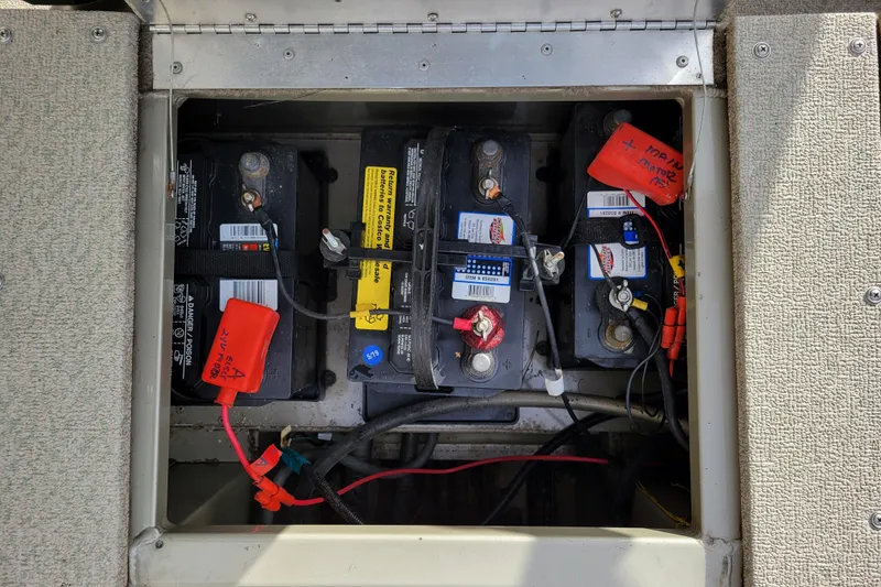 Slide: The Image of 2005 Lowe Fish & Ski 165 boat battery compartment with three installed batteries. - 25