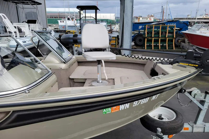 Slide: The Image of 2005 Lowe Fish & Ski 165 boat at marina, featuring a swivel seat and trolling motor. - 7