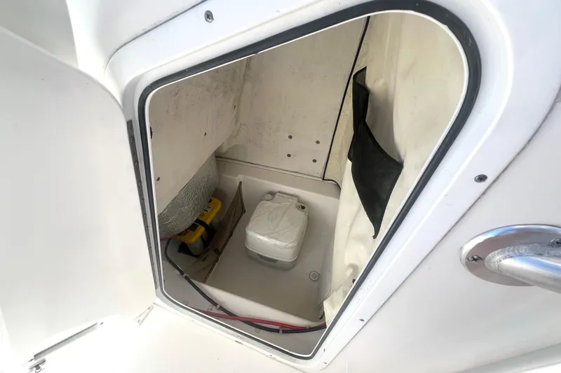 Slide: The Image of Storage compartment inside 2016 Sea Fox 186 Commander boat, featuring a battery and netting. - 18