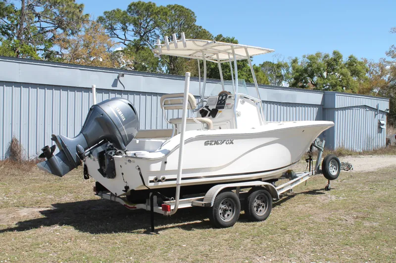 Slide: The Image of 2016 Sea Fox 186 Commander boat on trailer, parked outdoors near a metal building. - 2