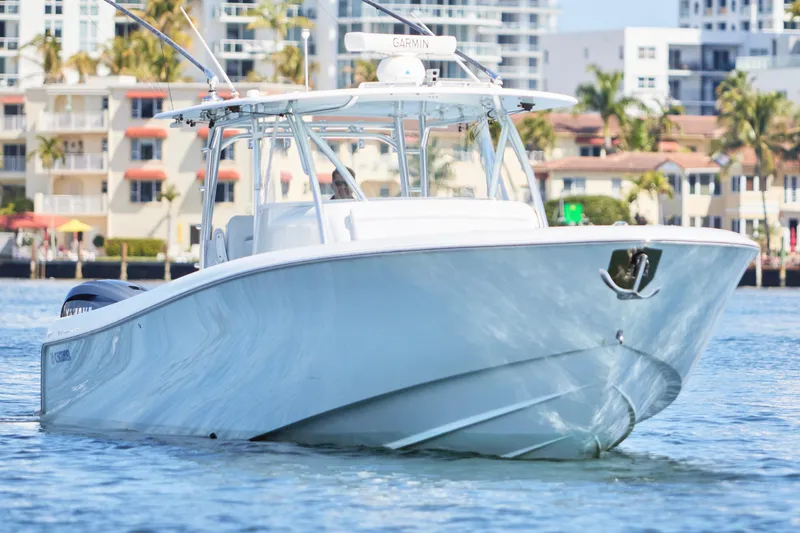 Slide: The Image of 2022 Contender 44 Fisharound boat cruising near waterfront buildings. - 6