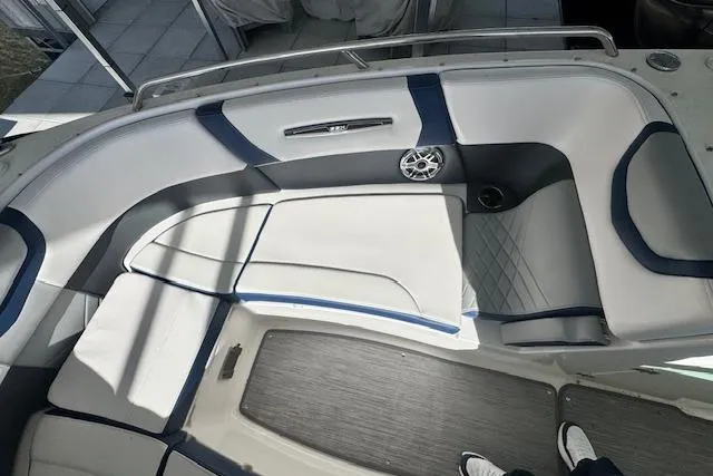 Slide: The Image of 2021 Chaparral 307 SSX boat interior with white and blue seating, speaker, and flooring. - 20