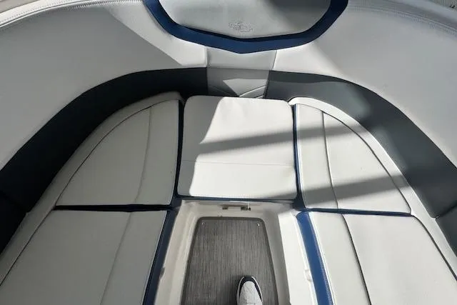 Slide: The Image of 2021 Chaparral 307 SSX boat interior with white cushioned seating and gray flooring. - 21