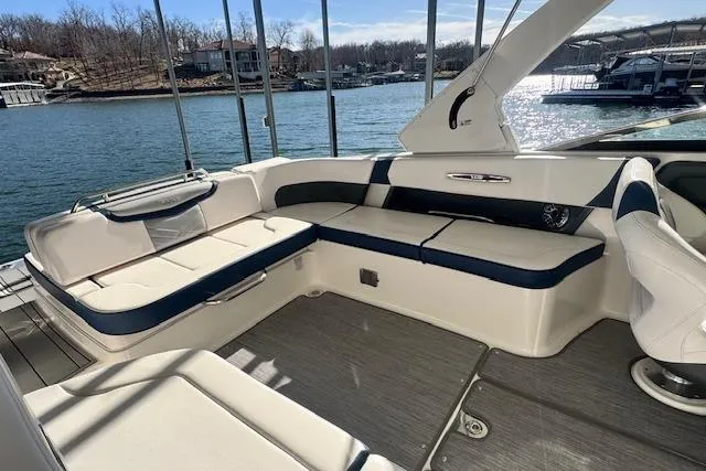 Slide: The Image of 2021 Chaparral 307 SSX boat interior with spacious seating, overlooking a serene lake. - 23