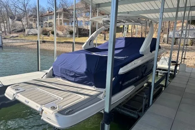 Slide: The Image of 2021 Chaparral 307 SSX boat docked with cover, lakeside view. - 35