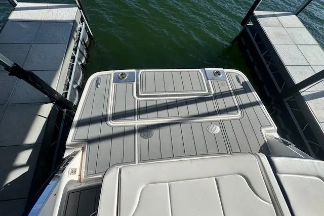 Slide: The Image of 2021 Chaparral 307 SSX swim platform with gray decking, docked on calm water. - 39