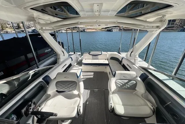 Slide: The Image of 2021 Chaparral 307 SSX boat interior with luxurious seating and lake view. - 6