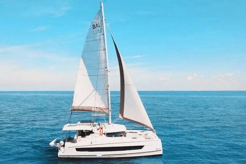 The Image of 2023 Bali CATSPACE catamaran sailing on open blue sea under clear sky. - 0