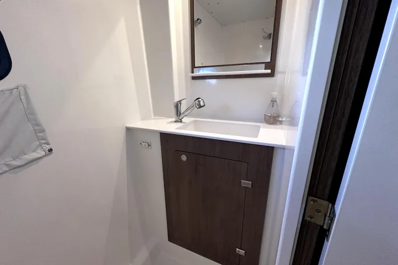 Slide: The Image of Modern bathroom sink area in 2023 Bali CATSPACE yacht, featuring sleek design and wooden cabinetry. - 27