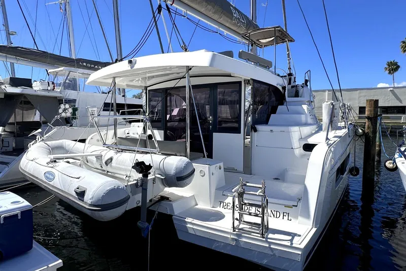 Slide: The Image of 2023 Bali CATSPACE catamaran docked, featuring a dinghy and spacious deck area. - 5