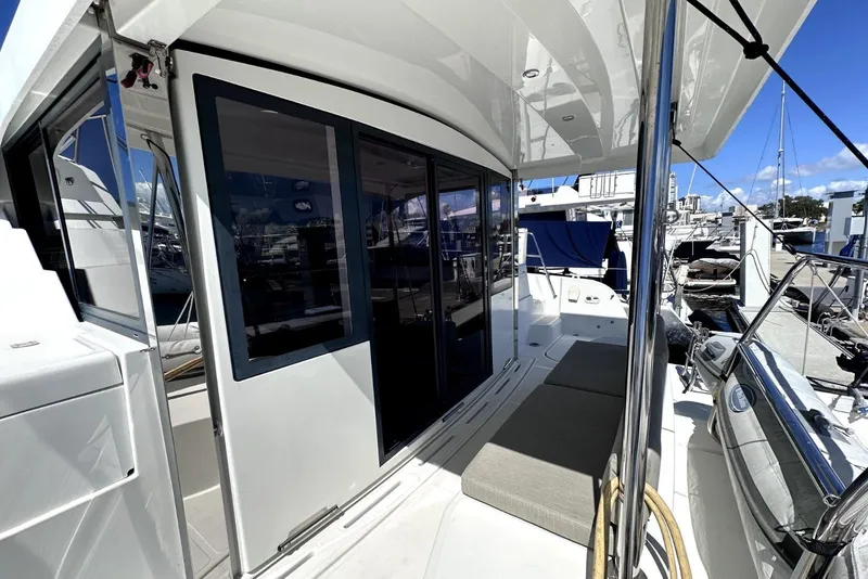Slide: The Image of 2023 Bali CATSPACE yacht deck with seating, sliding doors, and marina view. - 7