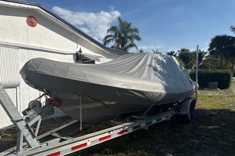 Slide: The Image of Covered 2022 Ribeye HFM boat on trailer beside house, under clear blue sky. - 22