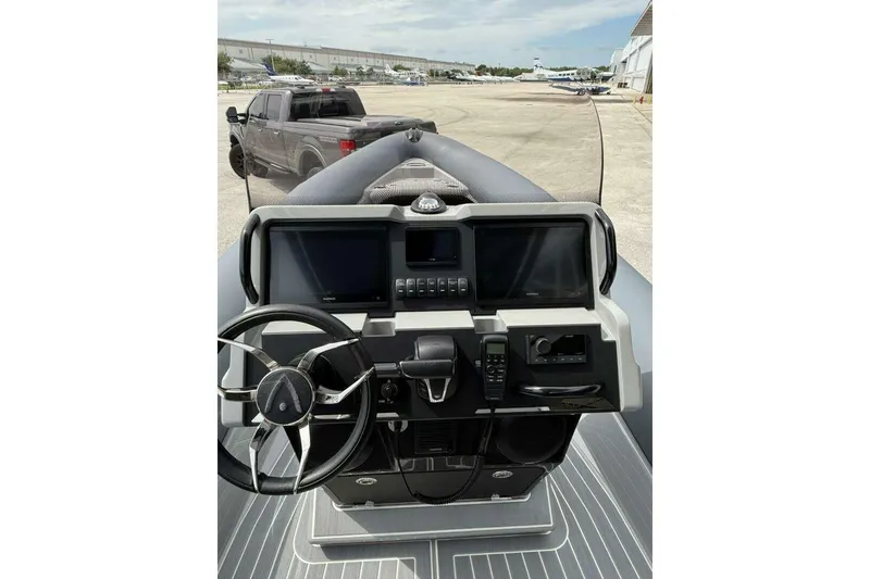 Slide: The Image of Control panel of 2022 Ribeye HFM boat with dual Garmin screens and steering wheel. - 25