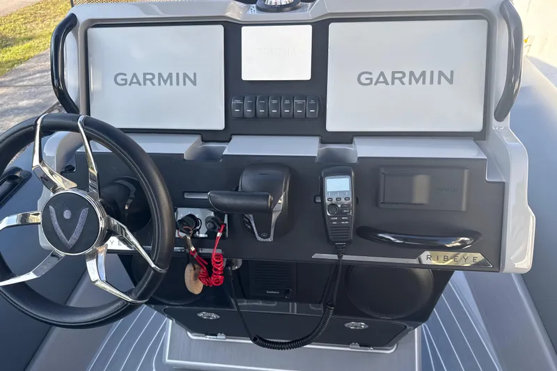 Slide: The Image of 2022 Ribeye HFM boat on trailer, parked outdoors with trees in background. - 9