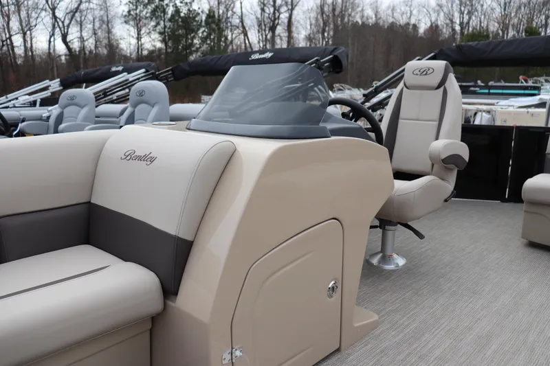 Slide: The Image of 2026 Bentley Pontoons Legacy 223 Cruise interior with beige seating and steering console. - 4