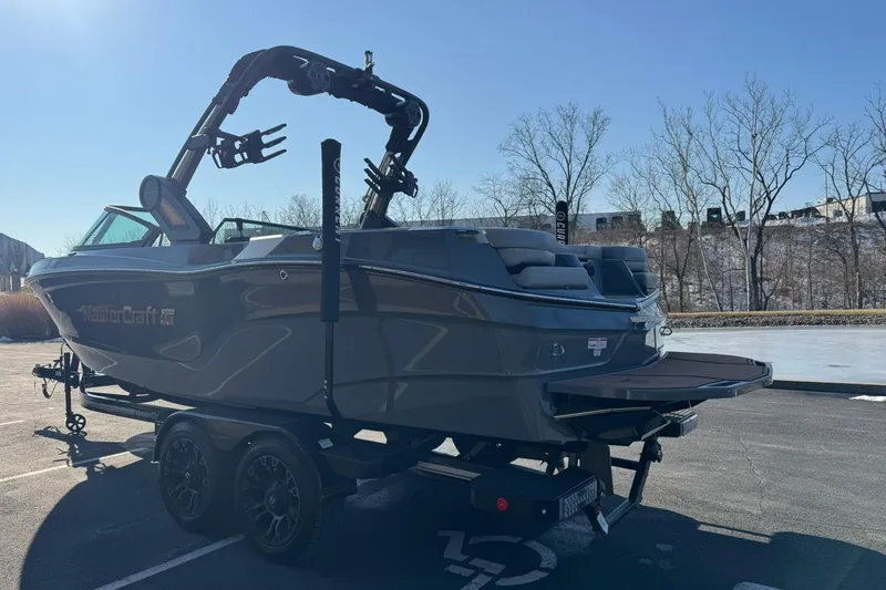 Slide: The Image of 2023 MasterCraft XT23 boat on trailer in sunny outdoor setting. - 5