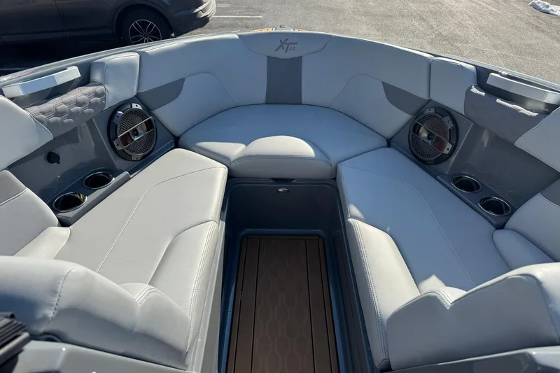 Slide: The Image of 2023 MasterCraft XT23 boat interior with gray seating and built-in speakers. - 7