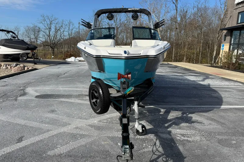 Slide: The Image of 2023 MasterCraft NXT23 boat on trailer in parking lot, clear sky background. - 14