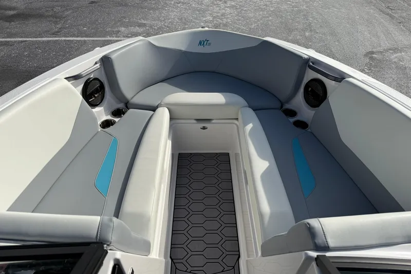 Slide: The Image of 2023 MasterCraft NXT23 boat interior with gray seating and hexagonal floor design. - 5