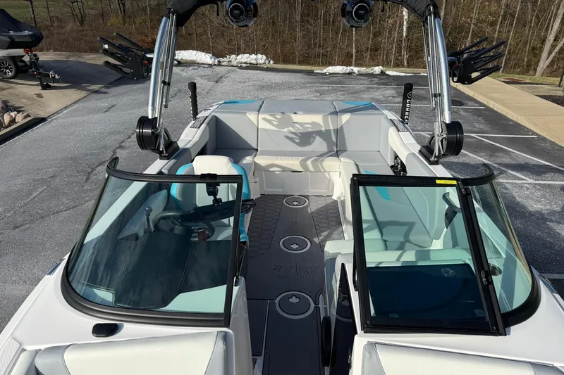 Slide: The Image of 2023 MasterCraft NXT23 boat interior with seating and wakeboard racks. - 6