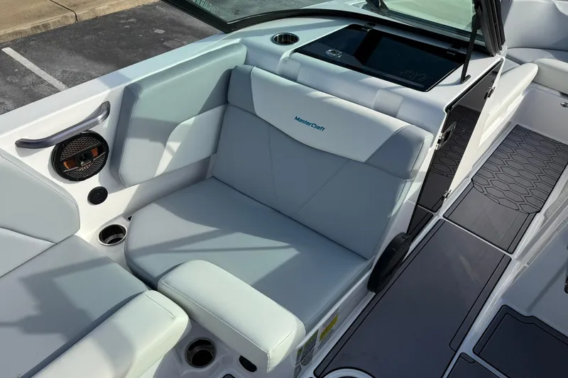 Slide: The Image of 2023 MasterCraft NXT23 boat interior with gray seating and speaker system. - 9
