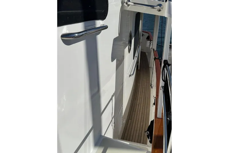 Slide: The Image of 2008 Kadey-Krogen 44 Walk Around yacht deck with polished railings and wooden flooring. - 10