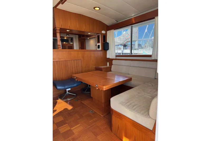 Slide: The Image of 2008 Kadey-Krogen 44 Walk Around interior with wooden dining area and cushioned seating. - 28