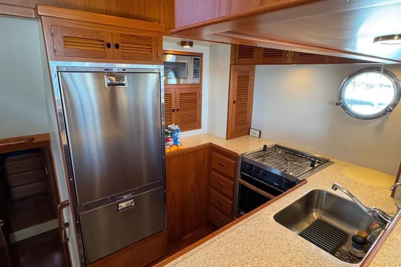 Slide: The Image of 2008 Kadey-Krogen 44 Walk Around yacht kitchen with stainless steel appliances and porthole window. - 36