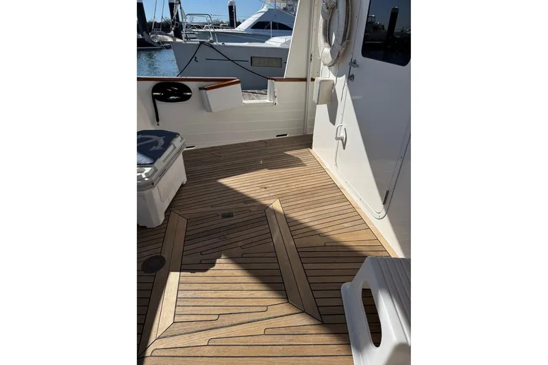 Slide: The Image of 2008 Kadey-Krogen 44 Walk Around yacht deck with wooden flooring and marina view. - 73