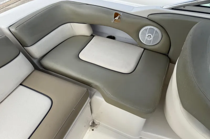 Slide: The Image of 2005 Sea Ray 220 Sundeck interior seating with speaker and minor upholstery damage. - 10