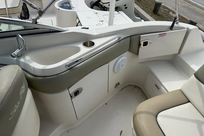 Slide: The Image of 2005 Sea Ray 220 Sundeck interior with seating, sink, and storage compartments. - 13