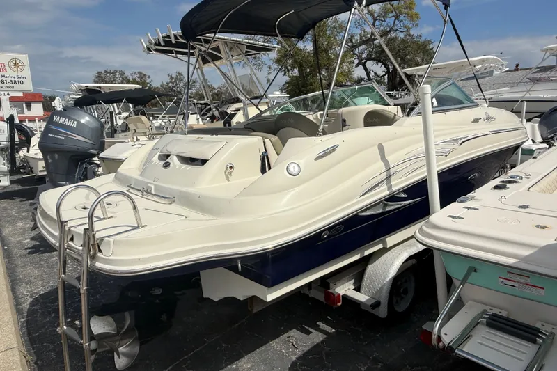 Slide: The Image of 2005 Sea Ray 220 Sundeck boat on trailer, parked in marina with other boats. - 3