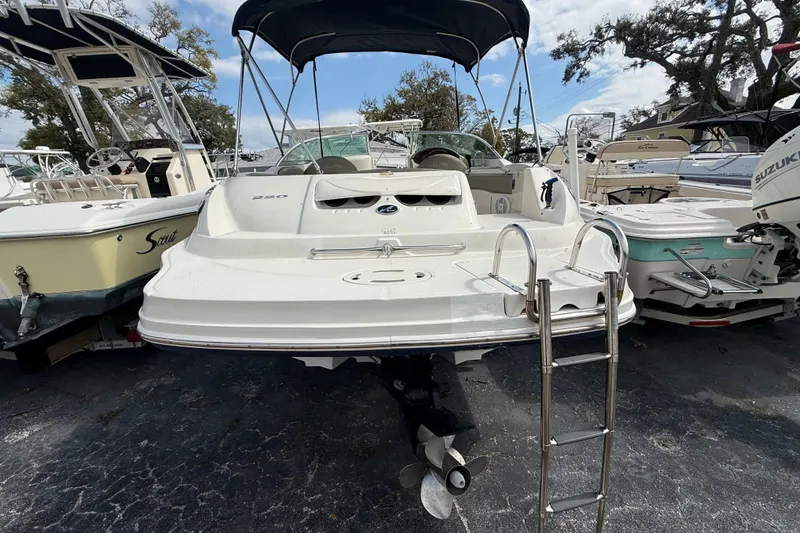 Slide: The Image of 2005 Sea Ray 220 Sundeck boat with ladder, parked among other boats. - 4