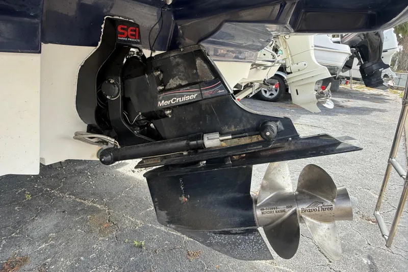 Slide: The Image of 2005 Sea Ray 220 Sundeck with MerCruiser Bravo Three outdrive, parked on asphalt. - 5