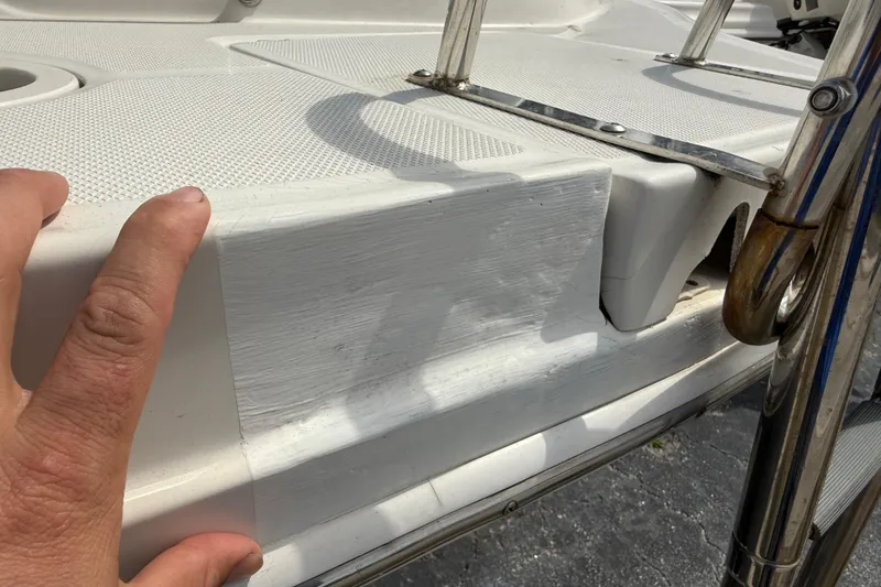 Slide: The Image of Hand touching the deck of a 2005 Sea Ray 220 Sundeck boat. - 7