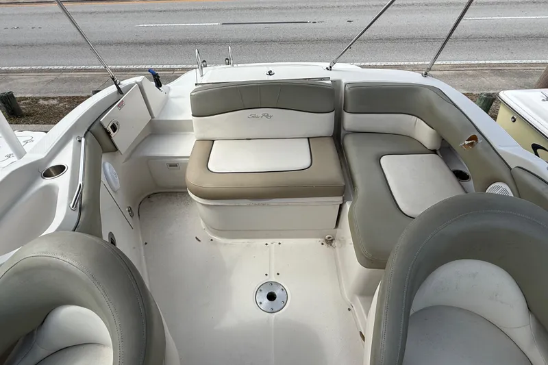 Slide: The Image of 2005 Sea Ray 220 Sundeck interior with beige seating and cup holders. - 9