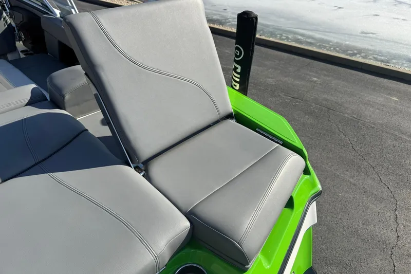 Slide: The Image of 2019 MasterCraft XT23 boat with gray seating and vibrant green accents. - 14