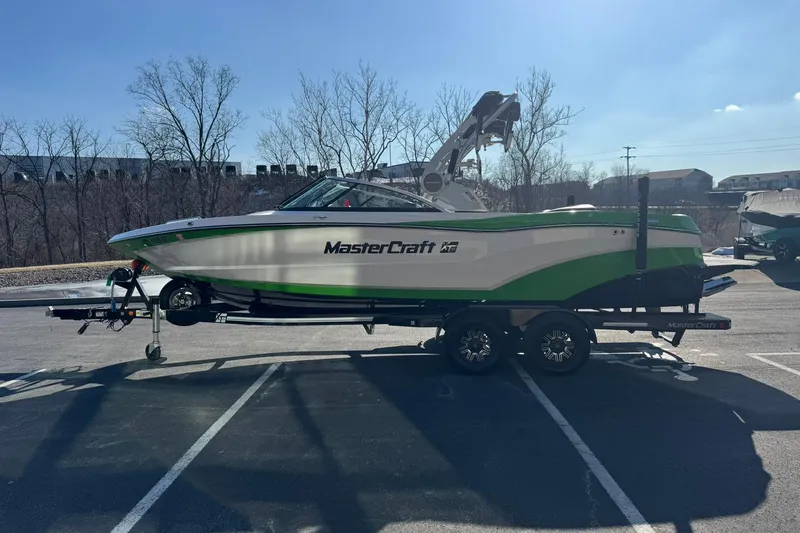 Slide: The Image of 2019 MasterCraft XT23 boat on trailer in parking lot, side view. - 7