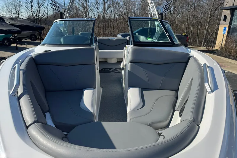 Slide: The Image of 2019 MasterCraft XT23 boat interior with gray seating, open bow design, and sleek windshield. - 8
