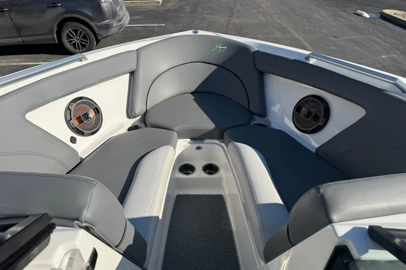 Slide: The Image of 2019 MasterCraft XT23 boat interior with gray seating and built-in speakers. - 9