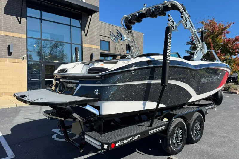 Slide: The Image of 2016 MasterCraft X23 boat on trailer, parked outside modern building. - 3
