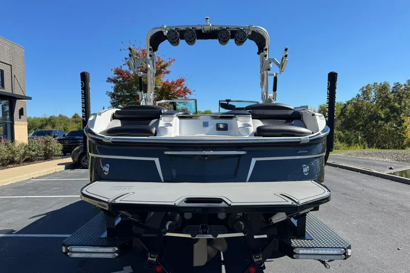 Slide: The Image of 2016 MasterCraft X23 boat, rear view, parked outdoors on a sunny day. - 4