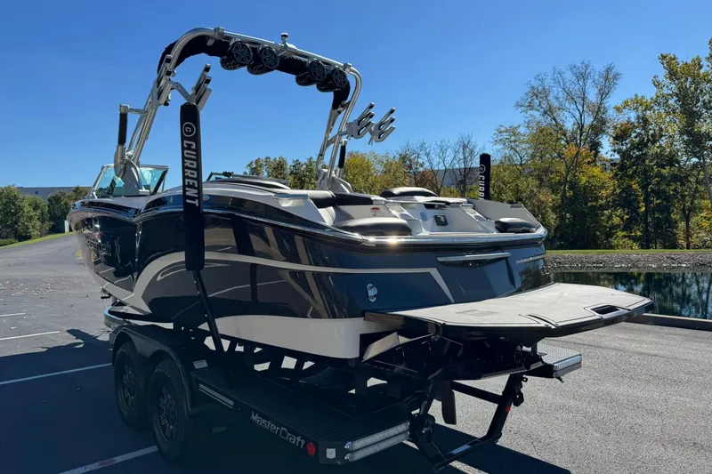 Slide: The Image of 2016 MasterCraft X23 boat on trailer, parked near a scenic lake. - 5